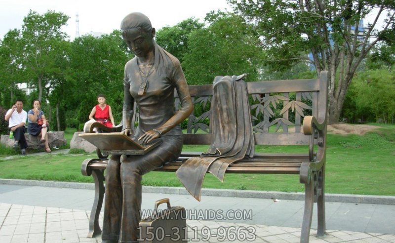 公园铜雕坐在长椅上看电脑的女孩博鱼网页版