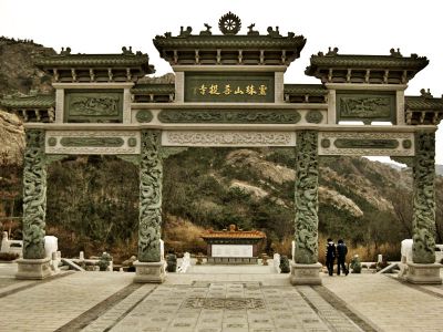 菩提寺院门前摆放龙柱浮雕三门青石牌坊