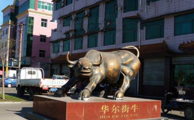 广场上摆放的铜色的玻璃钢创意华尔街牛