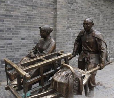 步行街摆放铸造推独轮车的人物黄铜博鱼网页版