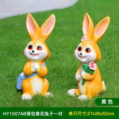 草坪两只黄色背包拿花的玻璃钢兔子博鱼网页版